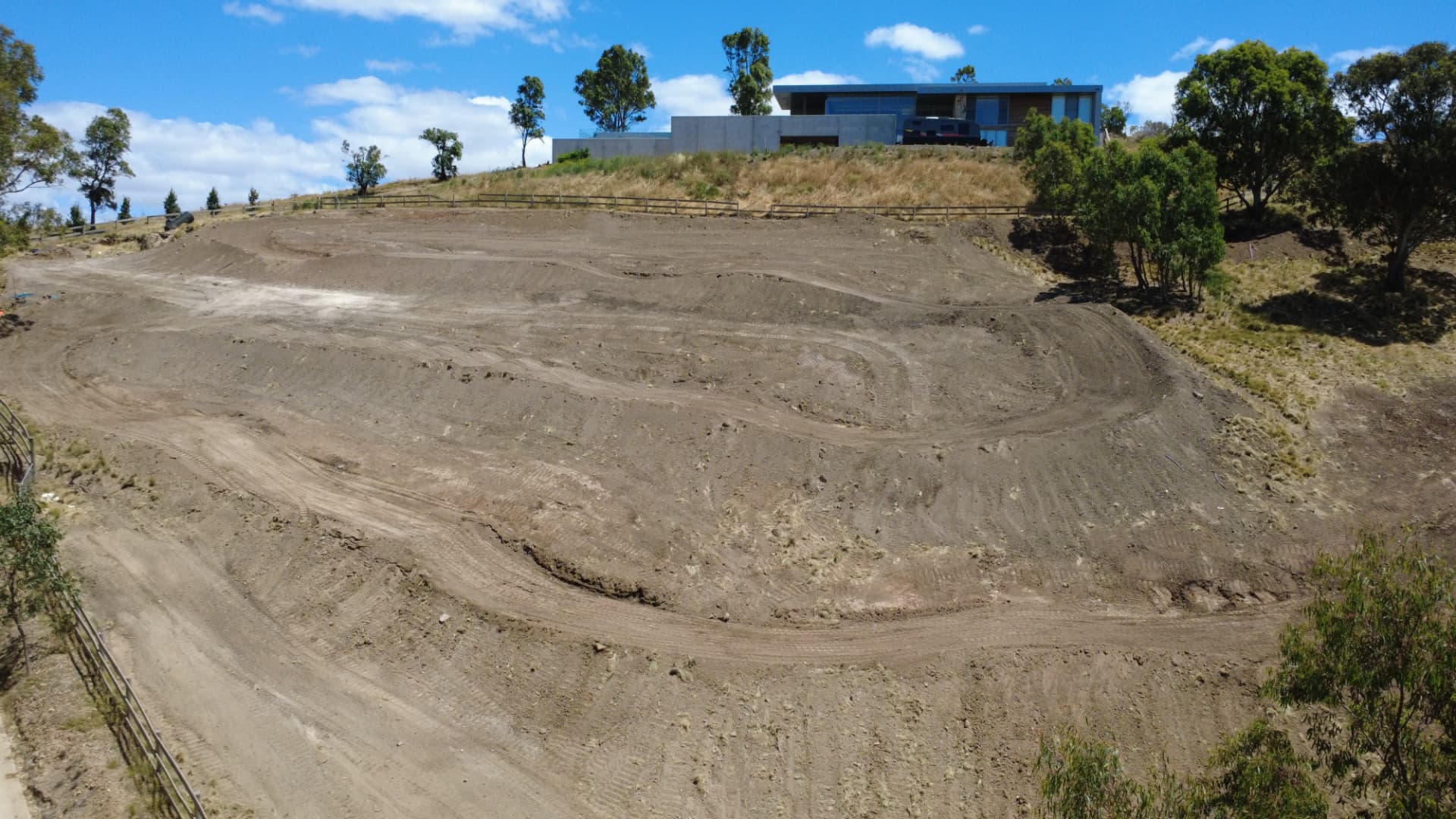 Aerial view of a private motocross track built on a sloped property