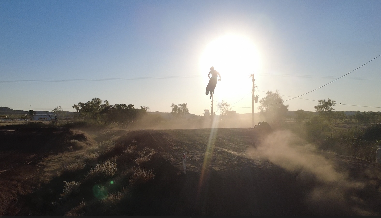 Rider silhouetted against the setting sun while test riding the Mount Isa track during the rebuild